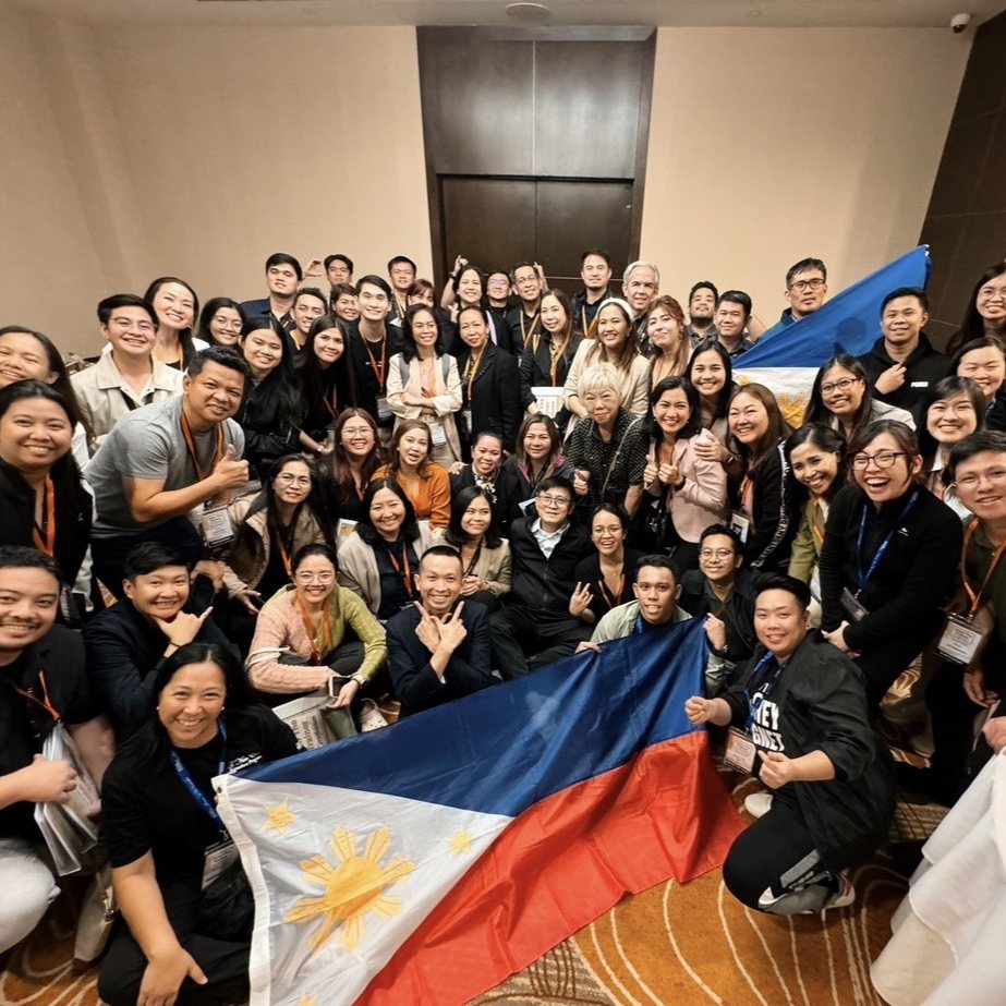 Group photo of attendees holding a Philippine flag